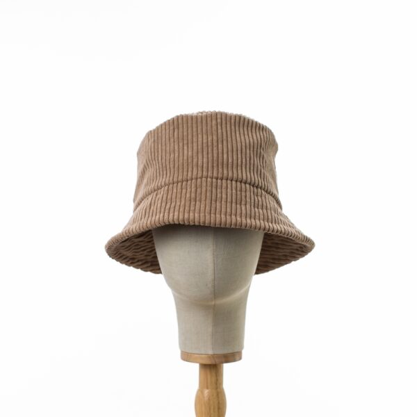 Head on view of Classic Bucket Hat made from thick ribbed beige corduroy fabric. The hat is positioned on a wooden hat stand.