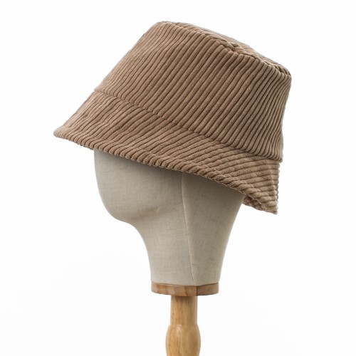 Classic Bucket Hat made from thick ribbed beige corduroy fabric. The hat is in profile .The hat is positioned on a wooden hat stand.